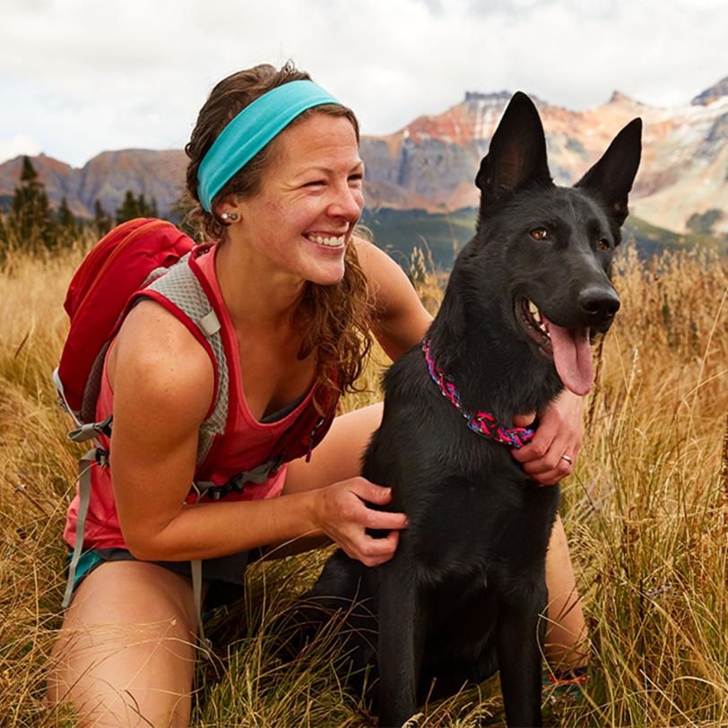 woman hugging black dog