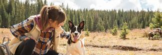 A woman petting a dog in a field